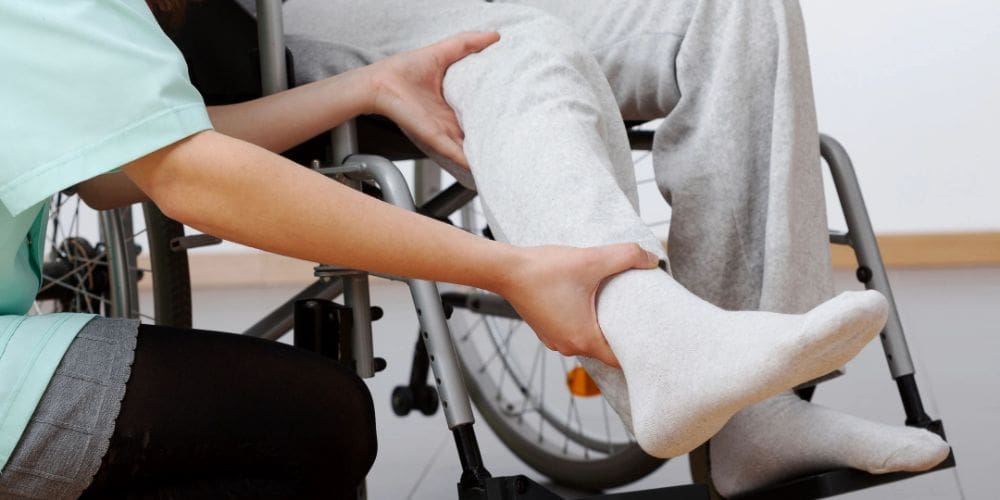 A person in a wheelchair with their arm wrapped up.